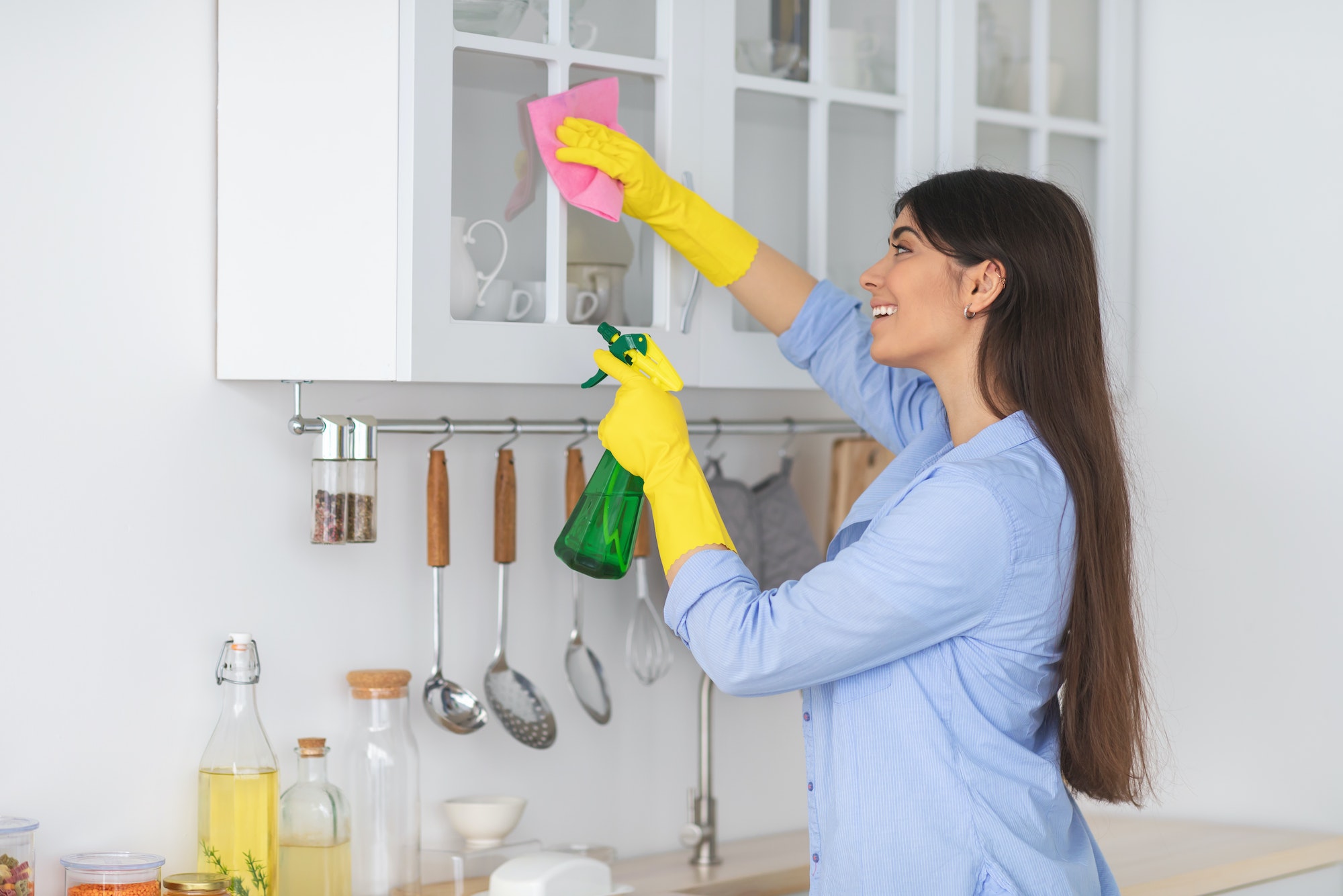 young-woman-cleaning-shelfs-at-home-at-kitchen.jpg